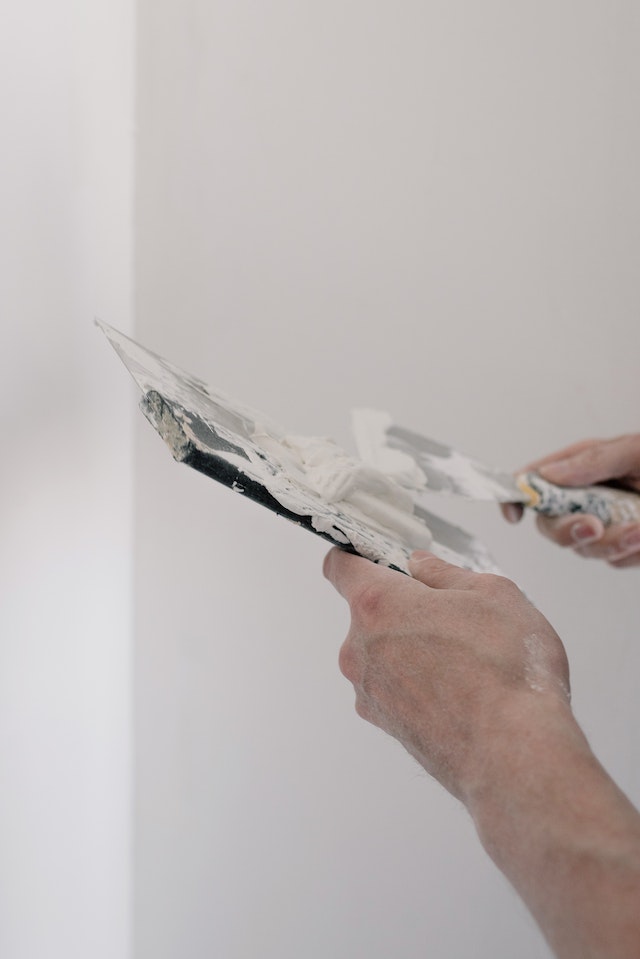 Person plastering white wall
