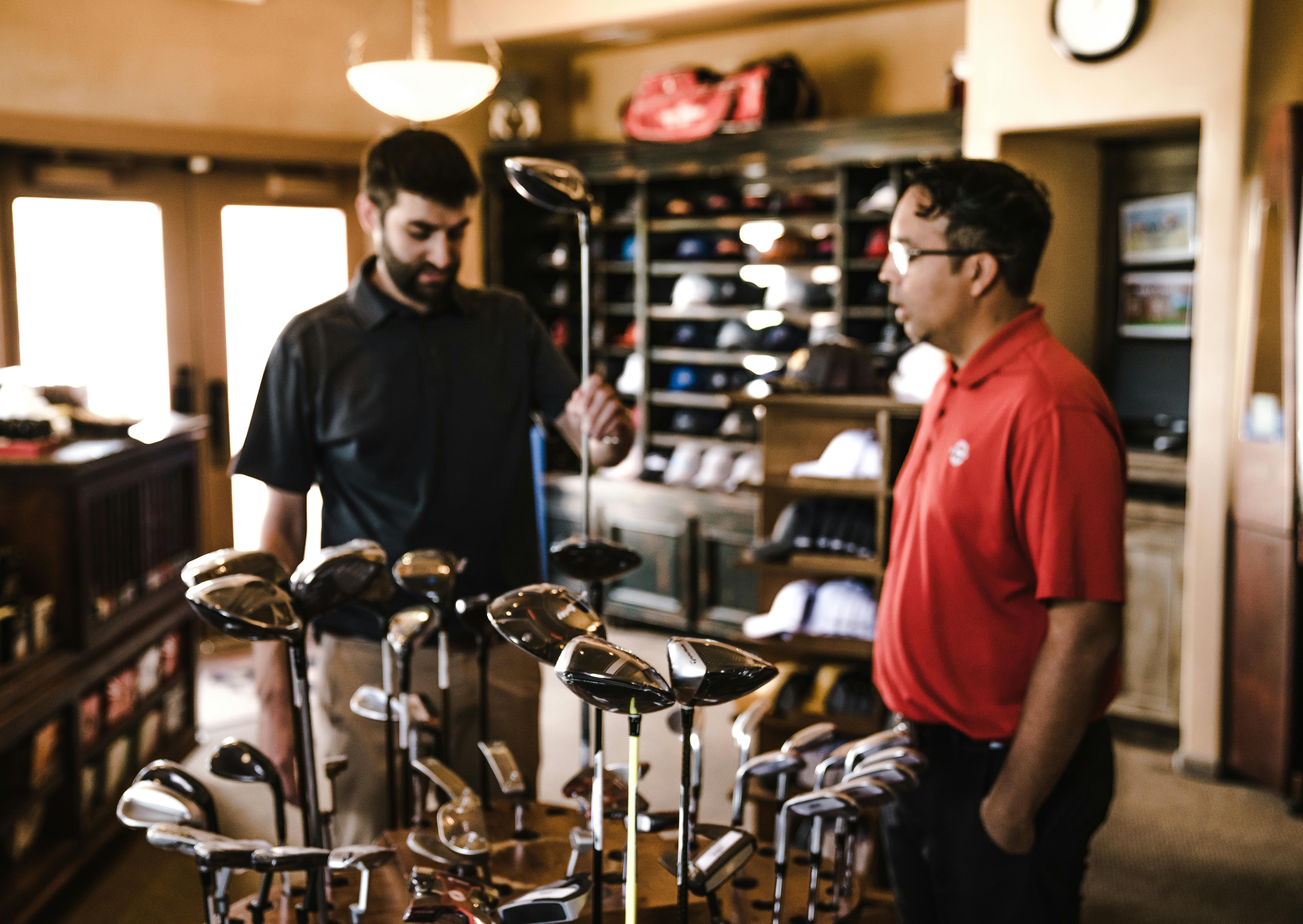 golf-pro-shop-helping-client-with-clubs